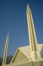 PAKISTAN, Islamabad, "Faisal mosque.  Detail of white rooftop and minarets against blue sky.