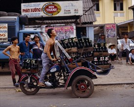VIETNAM, South, Ho Chi Minh , "Man riding motorbike laden with beer bottles,advertising posters "