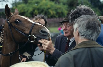 IRELAND , County Kerry  , Killorglin , Puck Fair.  Man checking horses teeth or age.