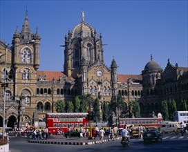 INDIA, Maharashatra, Bombay, Victoria Terminus railway station with traffic and people outside.