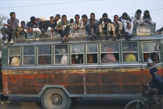 INDIA, Rajasthan, Fatehpur, Local bus crowded with people inside and on the roof