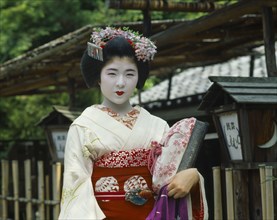 JAPAN, Honshu, Kyoto, Trainee Geisha in the Gion district dressed in red and white