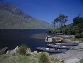 IRELAND, County Mayo, Doo Lough Lake, Small cove with rowing boats moored on the stoney shore