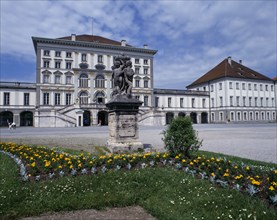 GERMANY, Bavaria, Munich, Nymphenberg Palace. Stone statue on plinth with flower bed in foreground