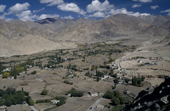 INDIA, Ladakh Region, View over valley with scattered houses and cultivated land surrounded by