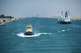 EGYPT, Suez Canal, Looking down Canal with tug approaching and ships moving away
