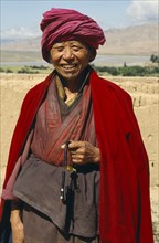 CHINA, Shandong Province, Near Guide, Tibetan Buddhist Monk by the Yellow River holding prayer