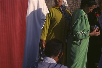 MOROCCO, General, Women at souk in bright coloured clothing
