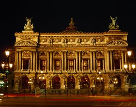 FRANCE, Ile de France, Paris, Opera frontage floodlit at night against black sky with light trails