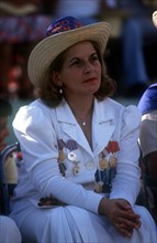 CUBA, Santiago, Seated woman dressed in white with medals pinned to the front of her jacket