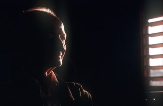 CUBA, Pinar del Rio, Portrait of an elderly farmer seen in a dark room with half of his face