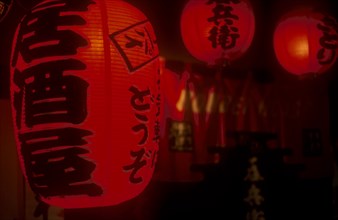 JAPAN, Honshu, Tokyo, Chochin Red Lanterns outside Izakaya Bar in Ichikawa district. Writing says
