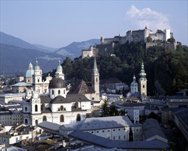 AUSTRIA, Salzburg Province, Salzburg, Hohensalzburg Fortress beyond town rooftops with wooded hills