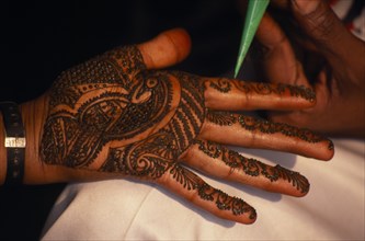 INDIA, Religion, Hindu, Hand of bride being decorated with henna paste for wedding.