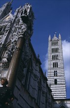 ITALY, Tuscany, Sienna, The front and side of the cathedral with the column of Romulus and Remus in