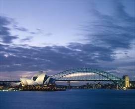 AUSTRALIA, New South Wales, Sydney, The Opera House and Harbour Bridge lit up at dusk