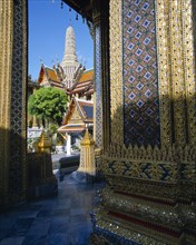THAILAND, Bangkok, Royal Palace - palace buildings seen past golden mosaic pillars