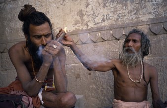 INDIA, Uttar Pradesh, Varanasi, Sadhus lighting and smoking chillum