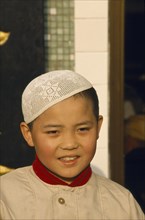 CHINA, Gansu, Lanzhou, Moslem boy wearing velvet beaded cap