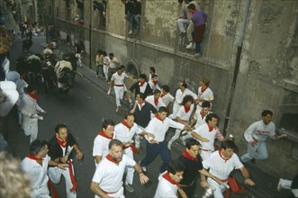 SPAIN, Navarra, Pamplona, San Fermin Bull Run Festival people running ahead of bulls in narrow