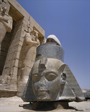 EGYPT, Nile Valley, Thebes, "The Ramesseum, large fallen carved stone head of Ramses II at foot of