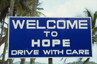 WEST INDIES, Tobago, Hope, Blue and white roadsign outside village reading Welcome To Hope Drive