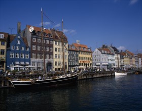 DENMARK, Zealand, Copenhagen, Nyhavn harbour. Traditional waterfront buildings with moored boats