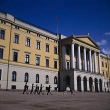 NORWAY, Akershus, Oslo, Royal Palace frontage with five guardsmen marching and sentry box