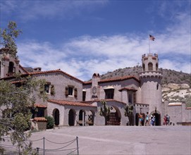 USA, California, Death Valley, Scotty's Castle. Large desert villa with tourists