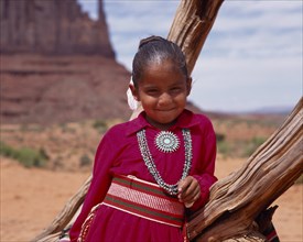 USA, Arizona, Monument Valley, Portrait of Navejo girl wearing a red dress and turquoise necklace