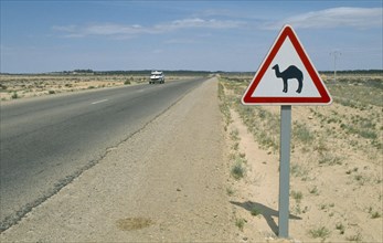 TUNISIA, Transport, Road Sign, Road sign warning motorists of camels on edge of Sahara desert.