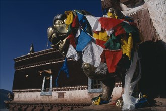 CHINA, Tibet, Lhasa, Potala Palace statue covered in prayer flags