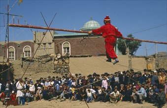 CHINA, Xinjiang, Kashgar, Acrobat Troupe performing tight rope walking in the street