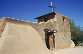 USA, Arizona, Tucson, De Grazias Mission church exterior with plain sandstone walls and floral