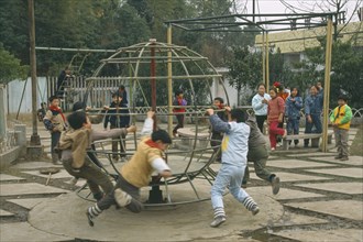 CHINA, Hunan, Huaihua, Children playing in park with climbing frames.