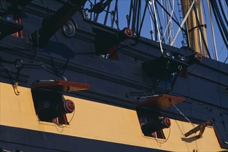 ENGLAND, Hampshire, Portsmouth, HMS Victory.  Detail of side of ship with cannons extending from
