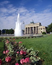 GERMANY, Berlin, Brandenburg Gate formal gardens and fountain.