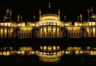 ENGLAND, East Sussex, Brighton, The Royal Pavilion illuminated at night and reflected in the lilly