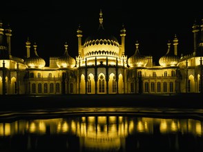 ENGLAND, East Sussex , Brighton, The Royal Pavilion illuminated at night with reflection in pond