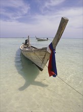 THAILAND, Krabi, Phi Phi Don, Lobagao Bay on the north of the island. Longtail boat moored off the