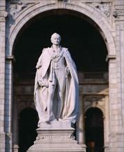 INDIA, West Bengal , Calcutta, Statue of Lord Curzon on pedestal framed by stone archway.