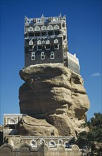 YEMEN, Wadi Dhar, Palace of the Rock, View looking up at grey and white building perched on top of
