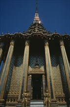 THAILAND, Bangkok, Grand Palace, Wat Phra Kaeo. View looking up at golden facade columned entrance