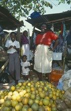 WEST INDIES, Jamaica, Ocho Rios, Fruit stall in the market with two female vendors and two children