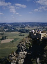 FRANCE, Aquitaine, Dordogne , Domme. People standing on a brick platform on a rocky hill looking