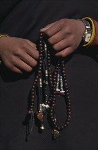 CHINA, Tibet, Terdrom, Close view of hands holding prayer beads.