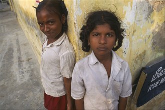 INDIA, Tamil Nadu, Pondicherry , Portrait of two schoolgirls standing on street corner.