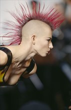 FASHION, Punk , Hairstyle / Piercing, Woman with Pink spiked hair running in narrow strip down her