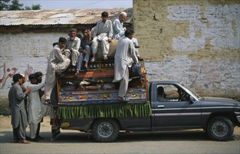 PAKISTAN, NW Frontier Province, Mingaora, Men crowded into and onto roof of truck.