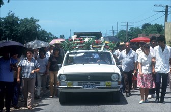 CUBA, Sancti Spiritus , Funeral procession with car carrying flowers and coffin on its roof